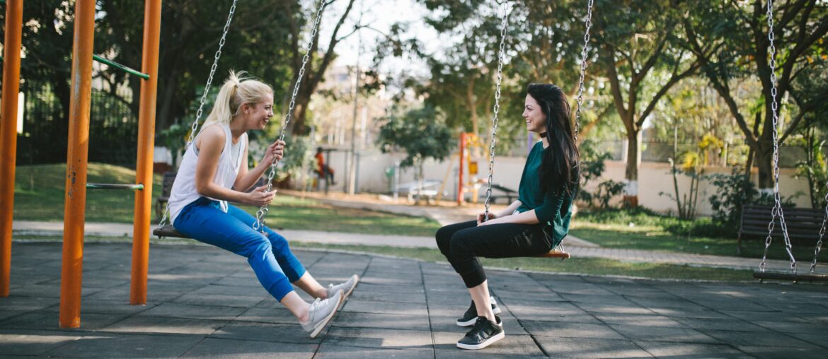 two girls on a swing chatting