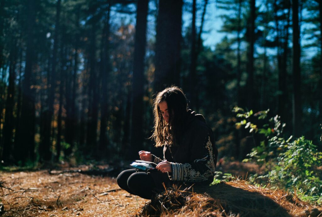 girl writing in a forest