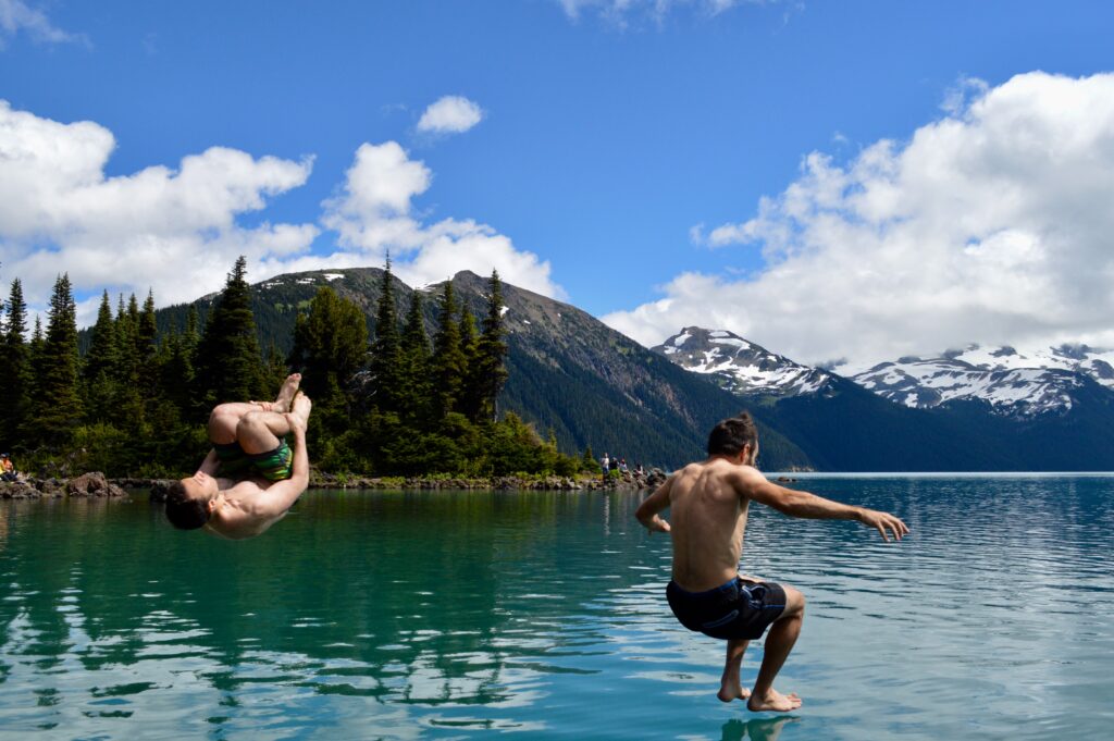 two guys jumping in a lake